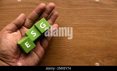 ESG concetto di ambiente, sociale e di governance. Mano che tiene il cubo verde scritto con le lettere e, S e G. Foto Stock