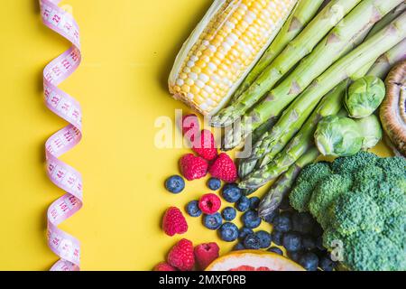 Scelta di cibo sano per il cuore, concetto di vita su uno sfondo a colori con copia spazio vista dall'alto. Alimenti che includono verdure, frutte. sana alimentazione fitn Foto Stock