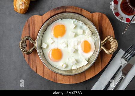 Sunny Side Up uova con formaggio feta in una padella di rame Foto Stock