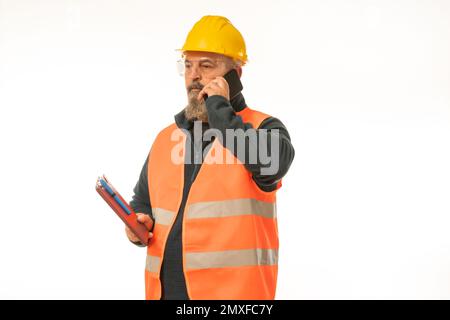 Un responsabile della costruzione caucasica attento che parla sul telefono cellulare su sfondo bianco Foto Stock