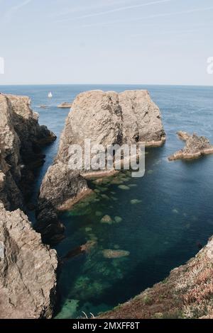 Una vista aerea verticale di enormi rocce nell'oceano in una giornata di sole Foto Stock
