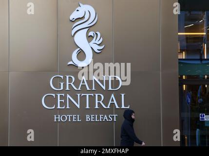 Uomo che passa davanti all'insegna dell'hotel nel centro di Belfast al Grand Central Hotel di Belfast - un hotel principale di Belfast. Foto Stock