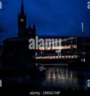 Wilight St Pancras stazione con venditore dolce stand illuminato in primo piano Foto Stock