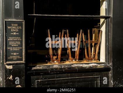 Sgabelli impilati capovolti all'interno della casa pubblica dei Mondi End Camden Foto Stock