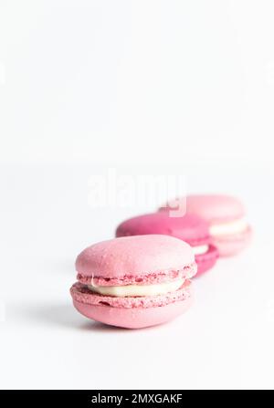 Pila di macaron rosa su sfondo bianco Foto Stock