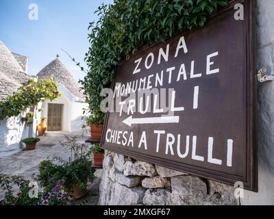 ALBEROBELLO, ITALIA - 29 OTTOBRE 2021: Cartello turistico ad Alberobello con case bianche Trulli in Italia Foto Stock