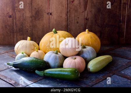 Il midollo e le zucche di verdure fresche sono accatastati sulla tavola in fienile. Foto Stock