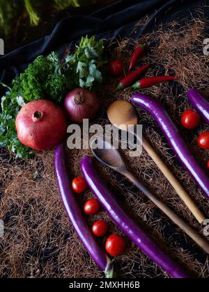 composizione creativa di vari ortaggi e frutta, come pomodori, uova di serpente, peperoncino rosso e cipolla prelevata dall'alto Foto Stock