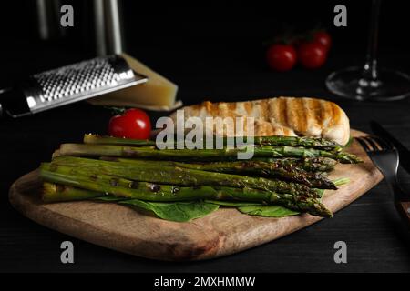 Gustoso filetto di pollo alla griglia servito con asparagi su tavola di legno Foto Stock