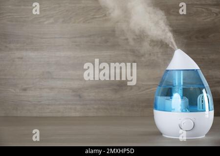 Moderno umidificatore d'aria su tavolo in legno. Spazio per il testo Foto  stock - Alamy