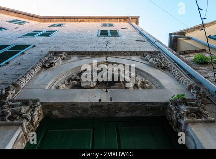 Sculture in pietra sopra la porta dell'antico edificio nella città vecchia di Cattaro, Montenegro Foto Stock