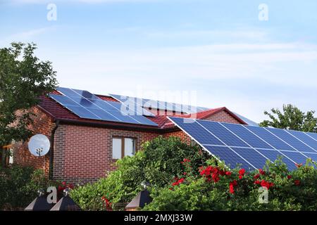 Casa con pannelli solari installati sul tetto. Fonte di energia alternativa Foto Stock