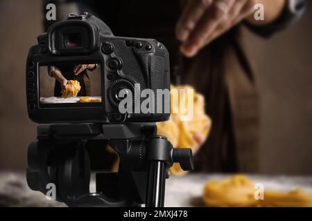 Fotografia di cibo. Ripresa di una donna che prepara pasta, focalizzazione sulla fotocamera Foto Stock