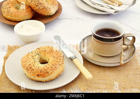 Bagel freschi e formaggio spalmabile per un caffè in formato orizzontale e shot in luce naturale. Foto Stock