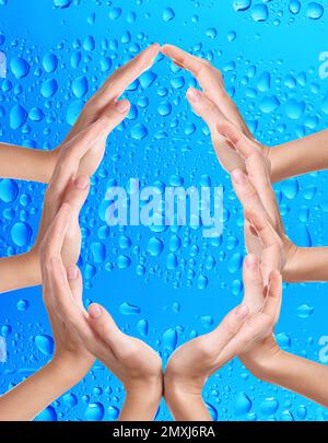 Donne che formano goccia d'acqua con le mani su sfondo blu. Protezione ecologica Foto Stock