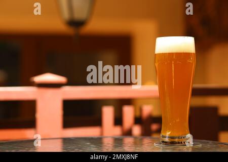 Bicchiere di gustosa birra sul tavolo all'aperto, spazio per il testo Foto Stock