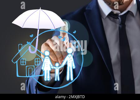 Concetto assicurativo - ombrello dimostrante protezione. Uomo che usa lo schermo virtuale con illustrazioni, primo piano Foto Stock