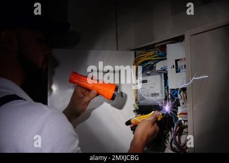 Elettricista che riceve scosse elettriche durante il lavoro, primo piano Foto Stock