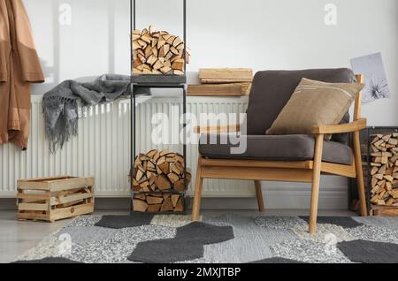 Legna da ardere vicino poltrona in elegante camera interna Foto stock -  Alamy