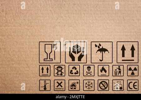 Scatola di cartone con simboli di imballaggio come sfondo, primo piano Foto Stock