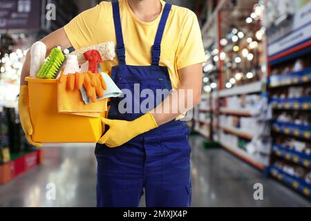 Janitor maschio con i rifornimenti di pulizia in centro commerciale, primo piano Foto Stock