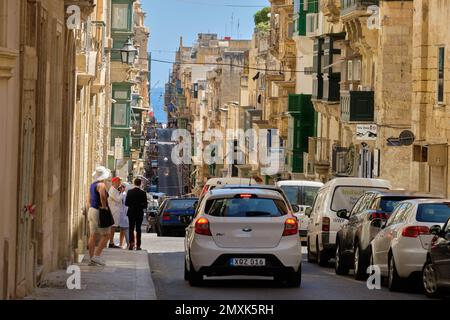 Passeggiando lungo St. Paul’s Street, una delle strade più autentiche della stretta griglia di la Valletta, Malta Foto Stock