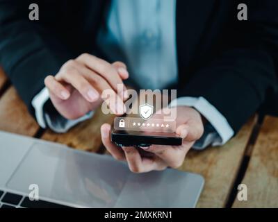 Concetto di autenticazione in due fasi (2FA). Codice delle icone 2023, Shield e asterisco visualizzato sullo smartphone mentre si utilizza il computer per convalidare la password, l'inserimento di dati Foto Stock