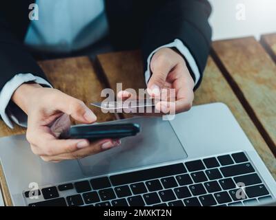 Concetto di pagamento sicuro. Icona dello scudo protettivo sulla carta di credito tenuta da parte di businessperson utilizzando l'acquisto di smartphone mobile in mano per lo shopping online, Foto Stock