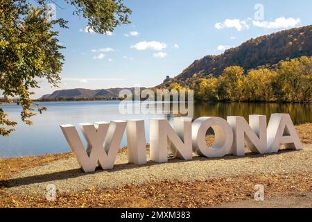 East Winona Lake con il cartello Winona e Sugar Loaf Bluff in lontananza (raggiungendo quasi 85 metri nel cielo) in una giornata autunnale a Winona, Minn. STATI UNITI. Foto Stock