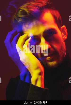 Doppia esposizione, colore e ritratto di un uomo con sovrapposizione isolata su uno sfondo scuro in studio. Struttura, design e volto di un uomo con arte colorata Foto Stock