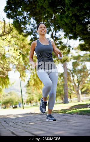 Shes sulla strada per il fitness. una giovane donna che corre nel parco. Foto Stock