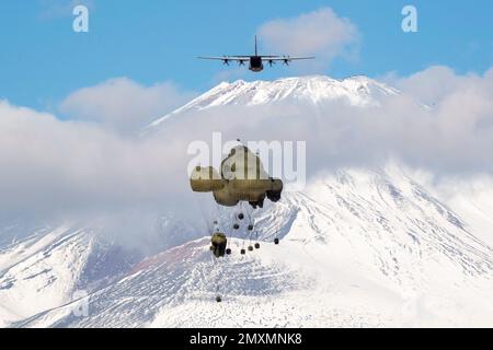 Shizuoka, Giappone. 31st Jan, 2023. I pacchetti del sistema pesante di consegna containerizzato (CDS) della forza di autodifesa di terra del Giappone cadono da un US Air Force C-130J Super Hercules assegnato al 36th Airlift Squadron a JGSDF East Fuji manovra Area, Giappone, gennaio. 31, 2023, durante Airborne 23. Nove aerei C-130J assegnati alla base aerea di Yokota e alla base aeronautica di Little Rock, Arkansas, sono stati utilizzati per trasportare circa 300 paracadutisti JGSDF e pacchetti CDS per far cadere le zone nel campo di addestramento di Higashi-Fuji durante la parte di salto del personale di linea statica dell'esercitazione. Il 2023 trasportato dall'aria è un o trasportato dall'aria su larga scala Foto Stock