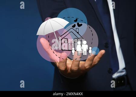 Concetto assicurativo - ombrello dimostrante protezione. Uomo con illustrazioni su sfondo scuro, primo piano Foto Stock