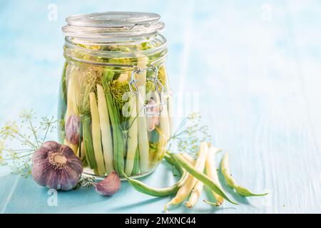 Fagioli verdi e gialli in scatola sani con galico e aneto. Pomodori di decapaggio a casa. Foto Stock