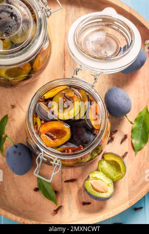 Prugne salate dolci e saporite in aceto con chiodi di garofano. Frutta conservata per l'inverno. Foto Stock