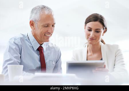 Tecnologia a supporto dei processi aziendali. due colleghi che utilizzano un tablet digitale al lavoro. Foto Stock