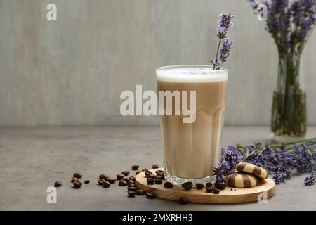 Delizioso caffè con lavanda e biscotti sul tavolo grigio. Spazio per il testo Foto Stock