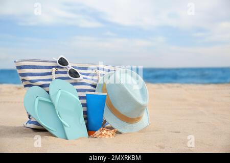 Diversi oggetti di stile spiaggia sulla sabbia vicino al mare Foto Stock