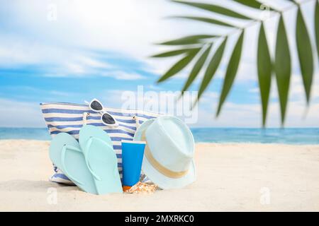 Diversi oggetti di stile spiaggia sulla sabbia vicino al mare Foto Stock