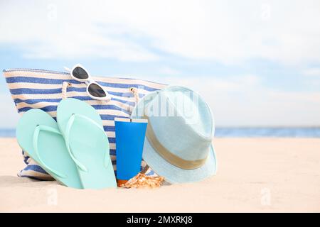 Diversi oggetti di stile spiaggia sulla sabbia vicino al mare Foto Stock