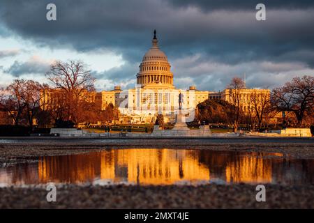 Il tramonto d'oro che cade sul Campidoglio degli Stati Uniti a Washington contro il cielo nuvoloso Foto Stock