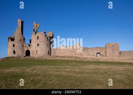 La fortezza del Castello di Dunstanburgh del 14th° secolo sulla costa del Northumberland, nel nord-est dell'Inghilterra Foto Stock