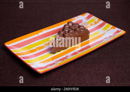 dessert al cioccolato con noci su un piatto in forma di gelato. Foto Stock