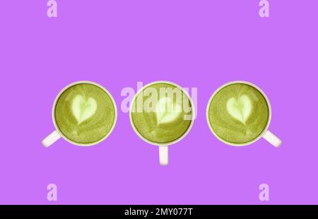 Tre di tè verde Matcha con latte Art a forma di cuore sono stati arransi su Lilac Bacckground Foto Stock