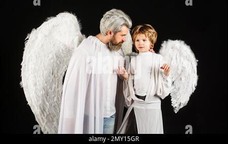 San Valentino. Padre e figlio in ali d'angelo. Piccolo cupietto e uomo bearded in vestiti bianchi. Foto Stock