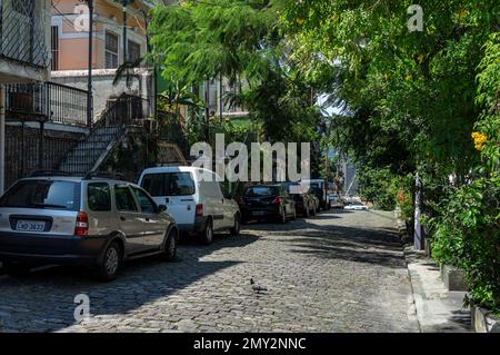 Auto parcheggiate su Ladeira de Santa Teresa strada di pista acciottolata nel quartiere di Santa Teresa zona residenziale sotto un pomeriggio estivo sole cielo blu giorno. Foto Stock