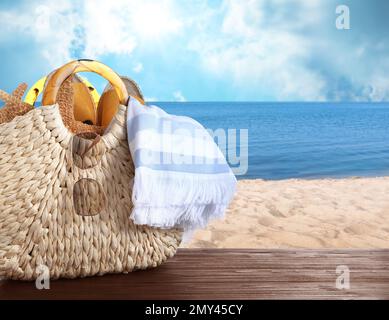 Oggetti spiaggia su tavola di legno vicino al mare, spazio per il testo. Vacanze estive Foto Stock