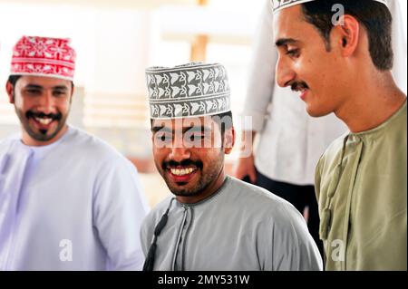 Gente comune, vestita tradizionalmente, al mercato di bestiame di Nizwa - Oman Foto Stock