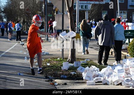 Raleigh, NC, USA, 4th febbraio 2023, Un corridore lancia una scatola vuota di ciambelle Krispy Kreme a metà strada di uno sprint di 5 miglia dal campus della North Carolina state University. Gestito per la prima volta nel 2004 come un osino tra gli amici, l’annuale Krispy Kreme Challenge divenne rapidamente un finanziatore a favore dell’ospedale pediatrico della UNC. Il record del corso di 28:29 è stato stabilito in 2020 con un passo di 5:41/miglio, che include il tempo che mangia le ciambelle. Con l’esposizione nazionale il motto è “2.400 calorie, 12 ciambelle, 5 miglia, 1 ora”. Credit D Guest Smith / Alamy Live News Foto Stock