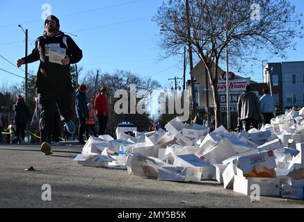 Raleigh, NC, USA, 4th febbraio 2023, Un corridore si sposta oltre un mucchio di scatole vuote di ciambelle Krispy Kreme a metà strada di uno sprint di 5 miglia dal campus della North Carolina state University. Gestito per la prima volta nel 2004 come un osino tra gli amici, l’annuale Krispy Kreme Challenge divenne rapidamente un finanziatore a favore dell’ospedale pediatrico della UNC. Il record del corso di 28:29 è stato stabilito in 2020 con un passo di 5:41/miglio, che include il tempo che mangia le ciambelle. Con l’esposizione nazionale il motto è “2.400 calorie, 12 ciambelle, 5 miglia, 1 ora”. Credit D Guest Smith / Alamy Live News Foto Stock